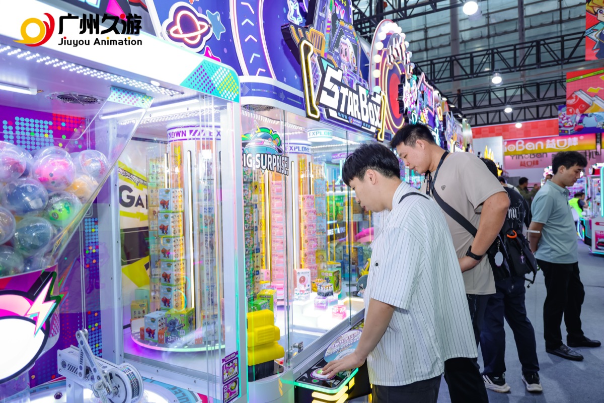 Visitors testing a Jiuyou Star Box prize machine at an amusement exhibition