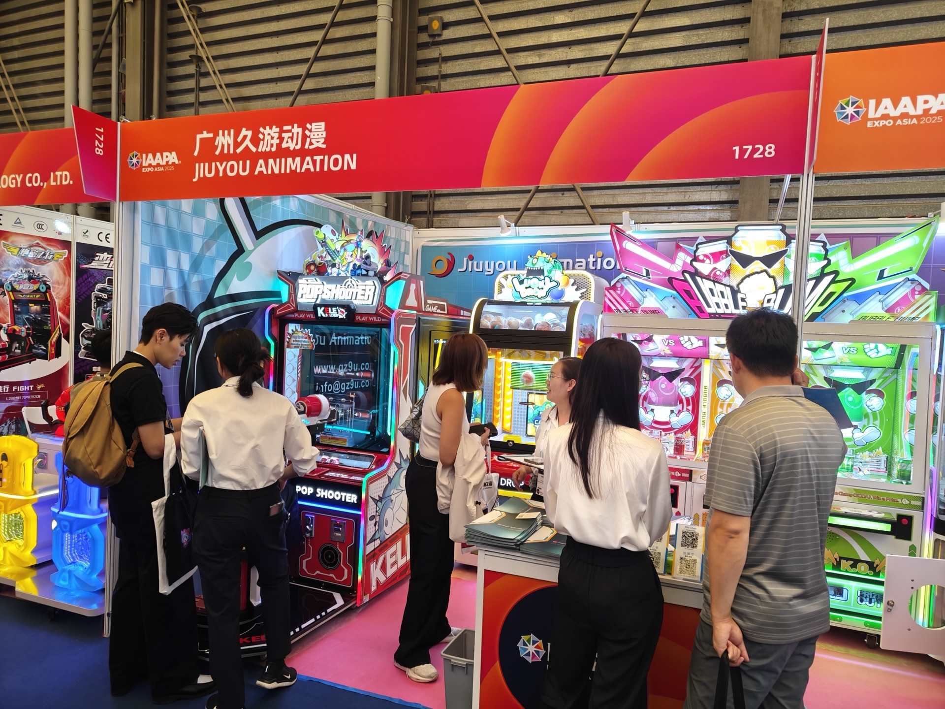 Jiuyou staff and arcade buyers discussing machines together on the exhibition floor